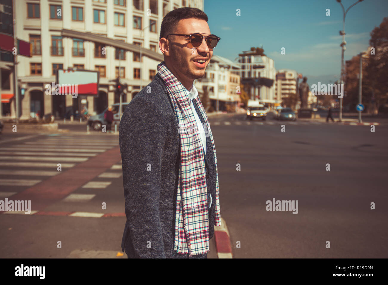 Un jeune homme moderne avec une belle écharpe et costume est debout dans le  centre-ville Photo Stock - Alamy