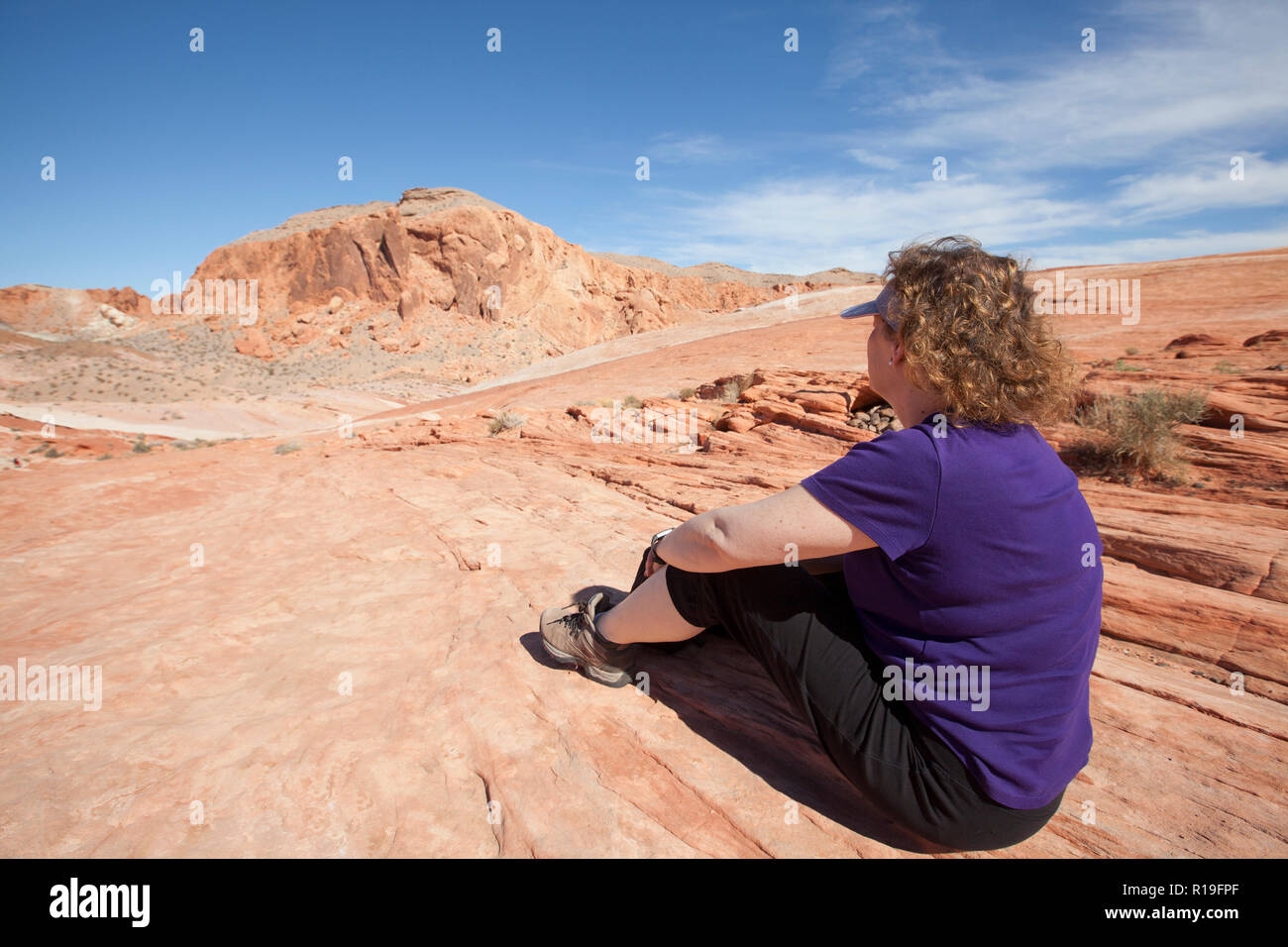 Randonneur femme se détendre et profiter de la vue sur la Vallée de Feu dans le Nevada State Park Banque D'Images