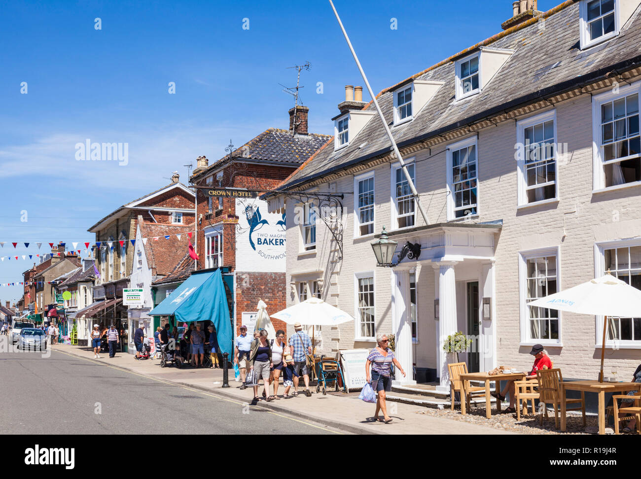 Suffolk Southwold personnes marchant passé la Couronne Hotel High street une ancienne auberge hôtel emblématique de Southwold Suffolk Southwold England UK GO Europe Banque D'Images