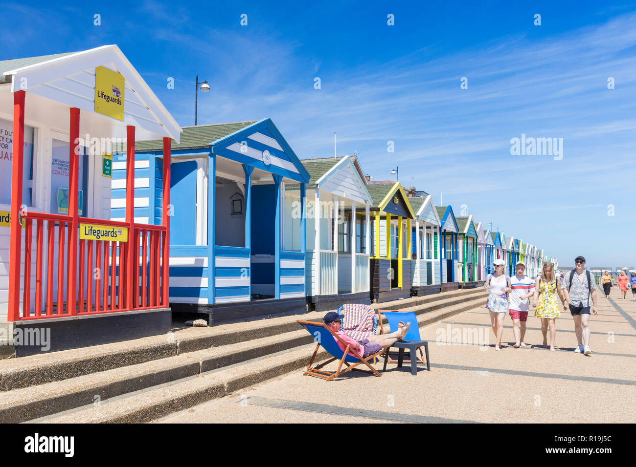 Cabines de plage de Southwold beach huts peint de couleurs vives, les vacanciers à la plage de Southwold North Parade East Anglia Suffolk Southwold England UK GO Europe Banque D'Images