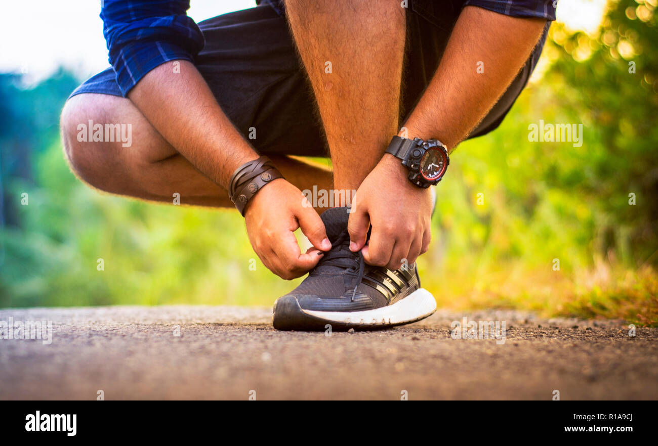 Jeune homme attachant lacets, coureur de fond Sports Banque D'Images