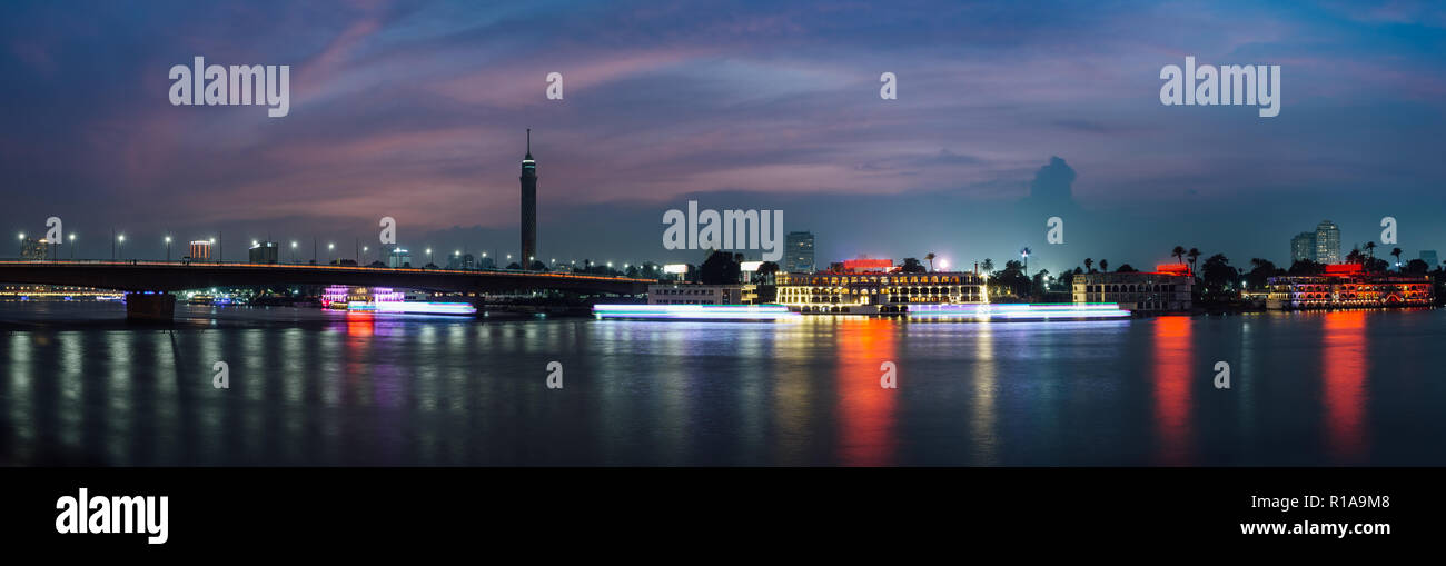 Vue panoramique du centre-ville du Caire, la nuit, une longue exposition avec légèreté de transport de bateaux sur le Nil. Banque D'Images