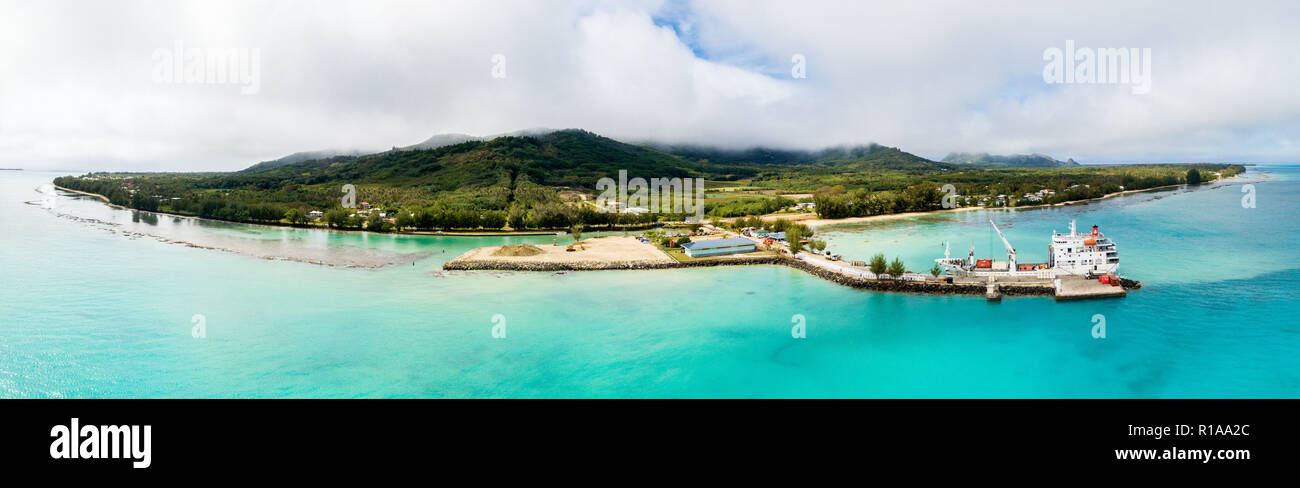 Vue aérienne de l'île de Tubuai et d'azur lagon bleu turquoise. Navire tuhaa pae IV le déchargement au port de Mataura, Australes, Polynésie Française Banque D'Images