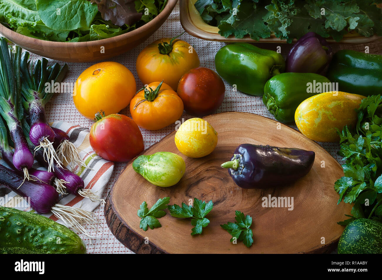 Scène de cuisine juste lavé super-aliments y compris le concombre, oignons, violet mesclun, tomates, chou vert, poivron vert, et le persil avec un tissu et Woo Banque D'Images