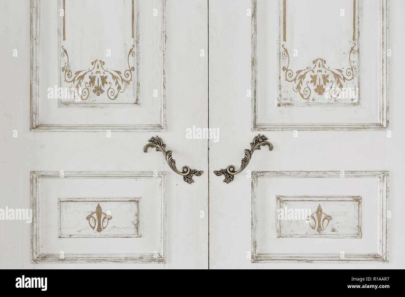 Grande porte blanche fermée et poignées en métal vintage. Banque D'Images