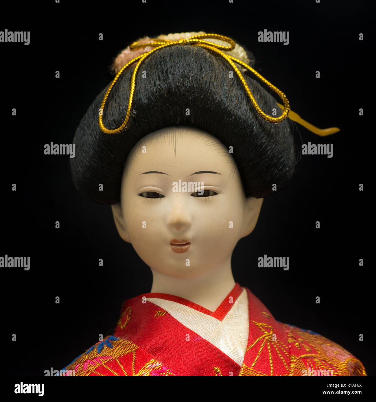 Poupée Geisha en kimono rouge isolé sur fond noir Banque D'Images