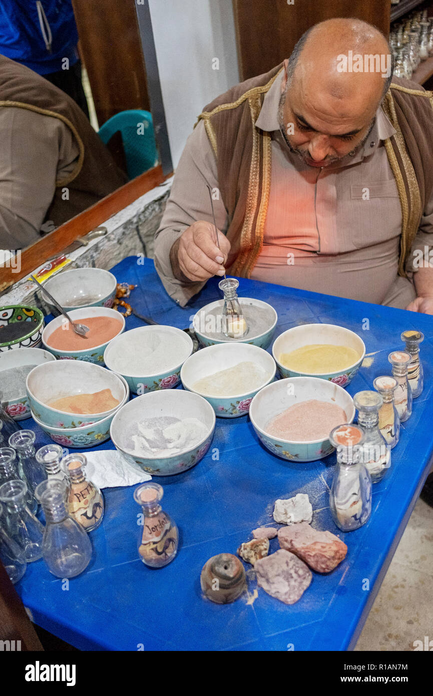 Un peintre de sable jordanien dans Rajif, Jordanie la peinture avec du sable. Dans un magasin de souvenirs près de Petra. Banque D'Images