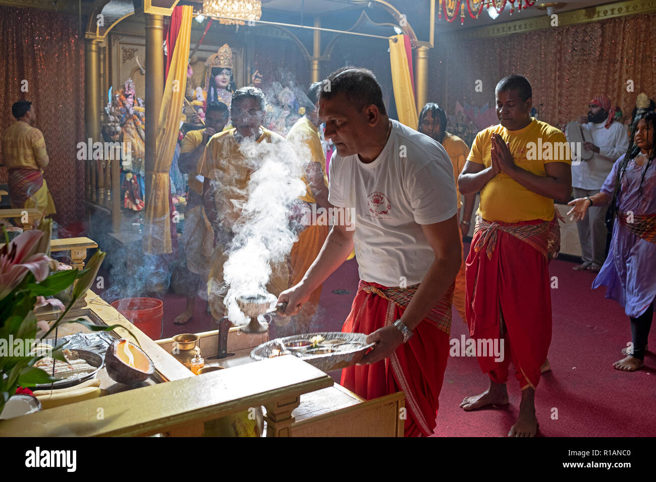Un dévot hindou brûle de l'encens en face de la déesse Kali à un temple hindou Shakti dans le Queens, New York. Banque D'Images