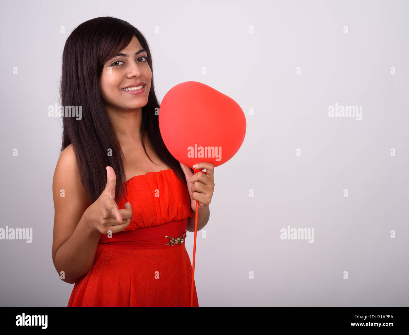 Studio shot of young woman smiling persan heureux tout en faisant Banque D'Images