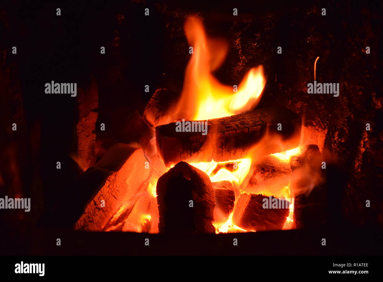 Close up of Brown les briquettes de charbon en feu avec flammes jaunes rouge à l'intérieur d'un four spécial, solide rouge et orange texture floue sur un fond noir. Banque D'Images