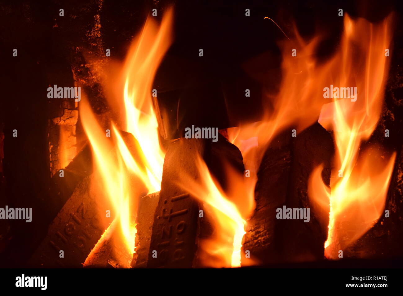 Close up of Brown les briquettes de charbon en feu avec flammes jaunes rouge à l'intérieur d'un four spécial, solide rouge et orange texture floue sur un fond noir. Banque D'Images