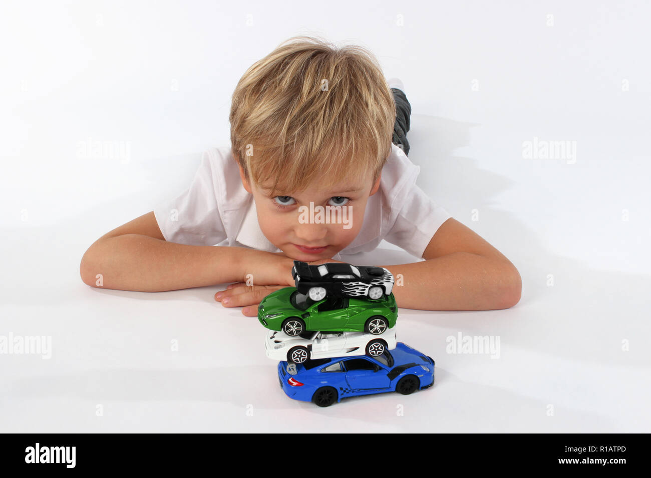 Enfant Garçon jouant avec des petites voitures dans un studio, construction d'une tour Banque D'Images