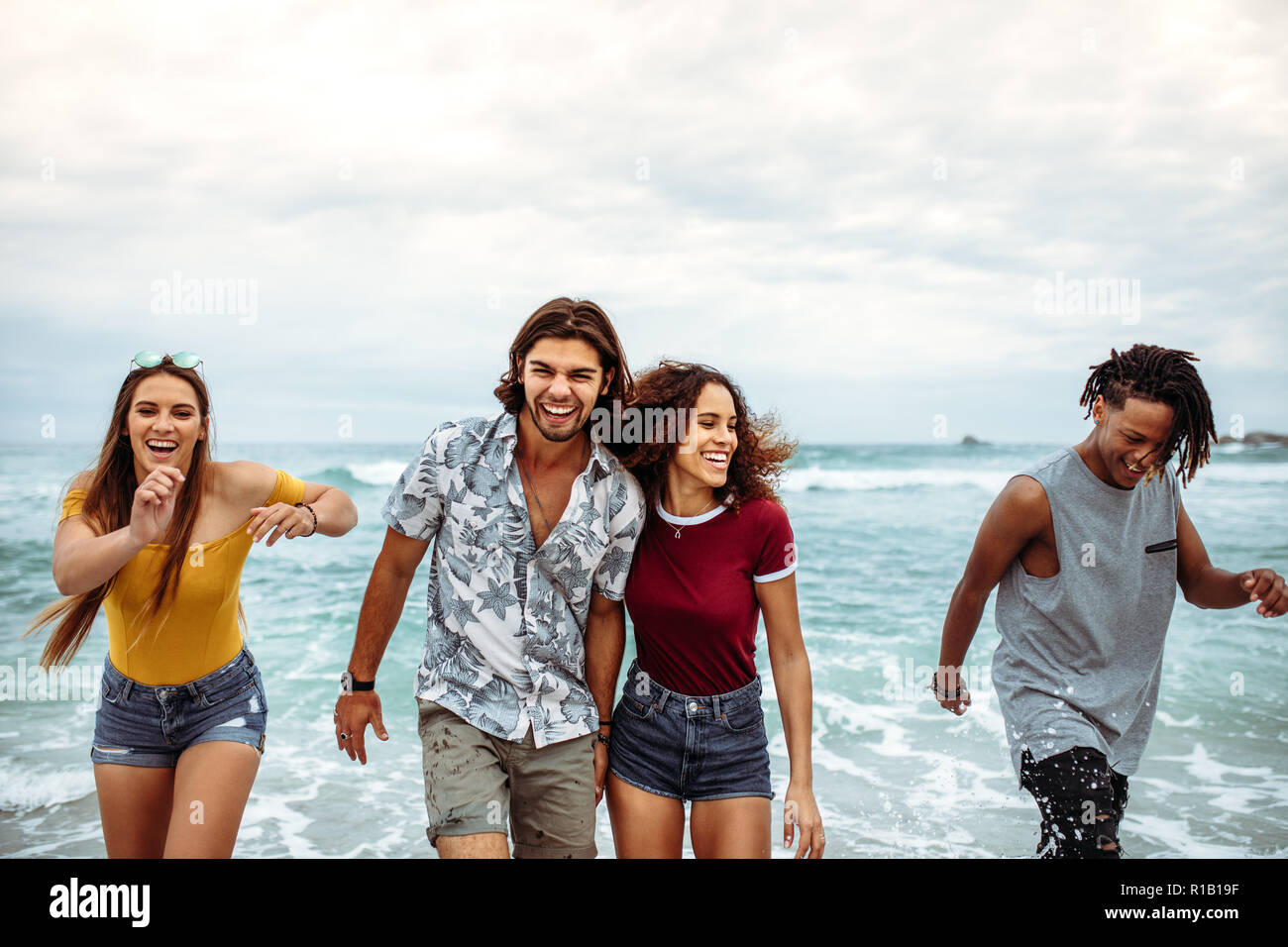 Carefree friends having fun le long du bord de mer. Les jeunes à la marche et faire une journée de vacances à la plage. Banque D'Images