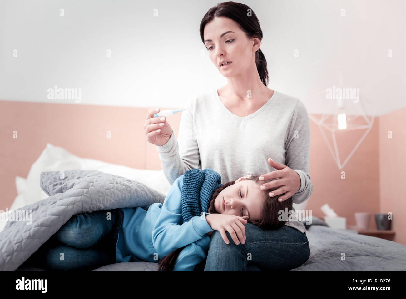 Portrait de mère inquiète thermomètre holding Banque D'Images