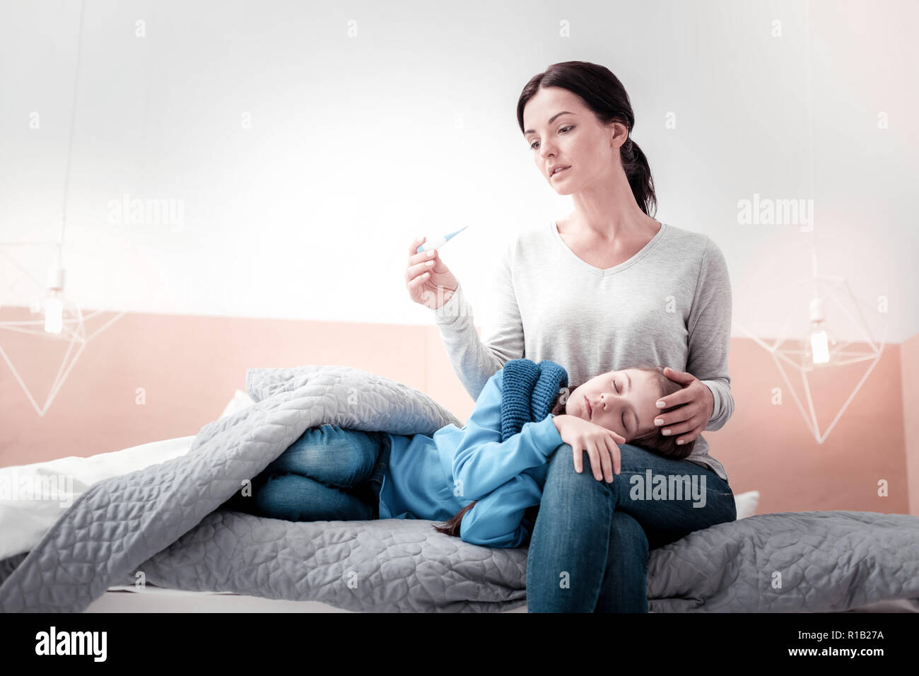 Triste mère étant inquiète de sa température de childs Banque D'Images