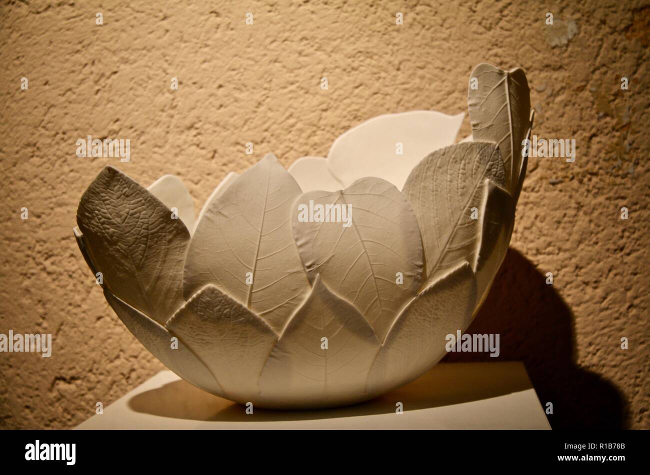 Un élégant fait main blanc leaf bowl contre un mur crème Banque D'Images
