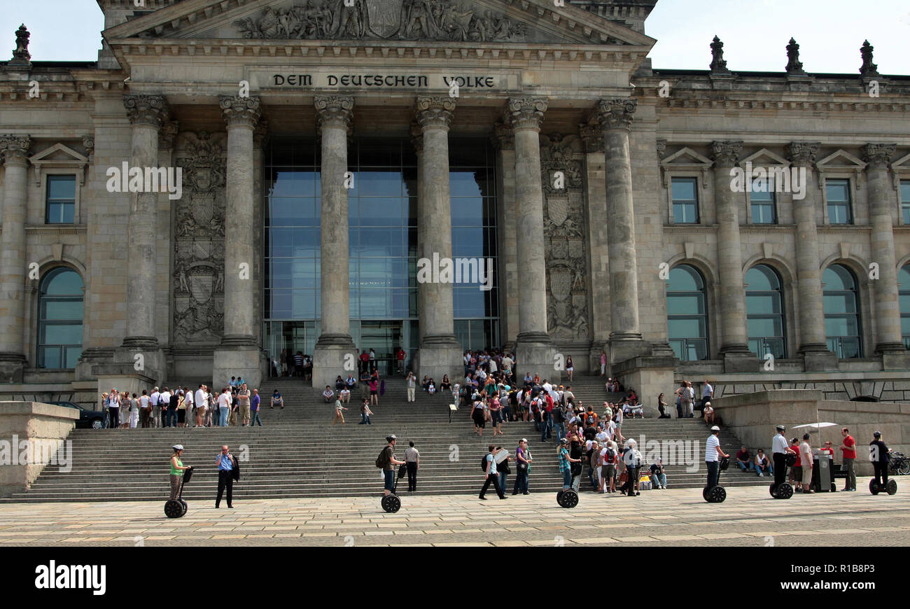 Un groupe de touristes glissent le Reichstag sur leurs Segways qui sont petites, electric, deux triporteurs. Certainement un moyen d'obtenir environ. Banque D'Images