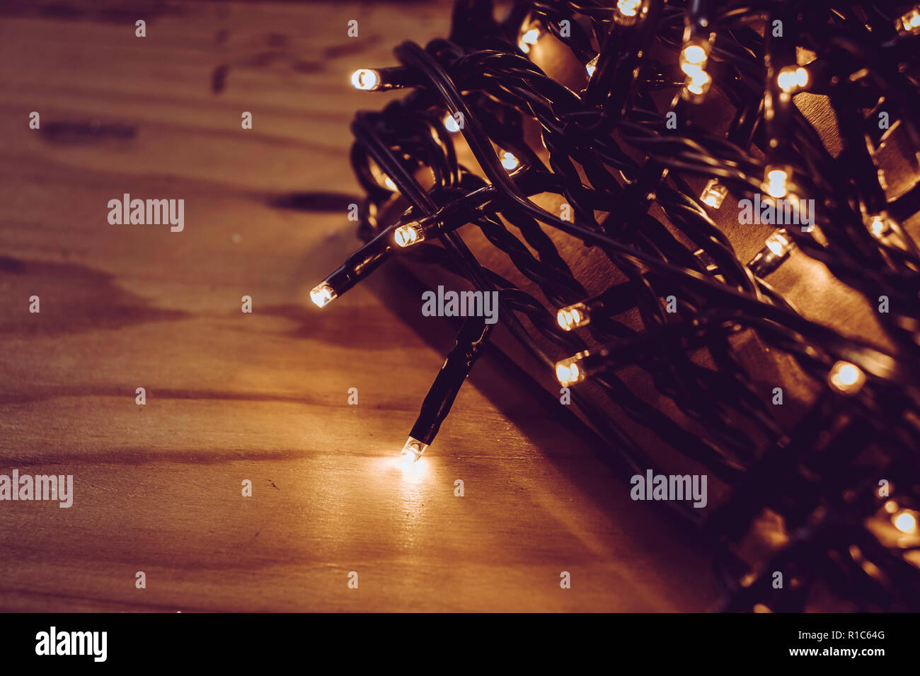 Guirlandes lumineuses de Noël carte enroulée autour de la nuit dans un cadre sombre Banque D'Images