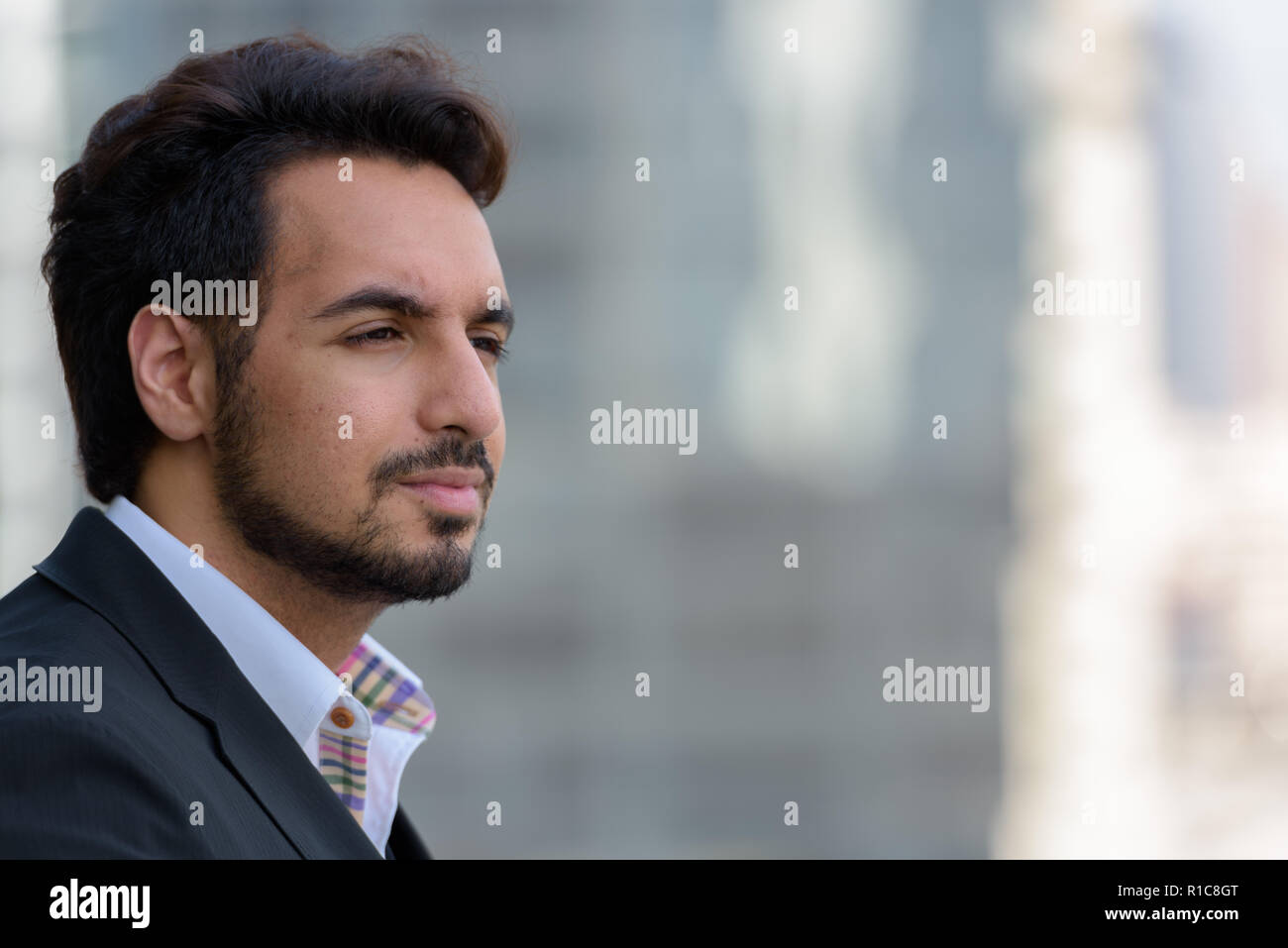 Close up of young handsome Indian businessman thinking outdoors Banque D'Images
