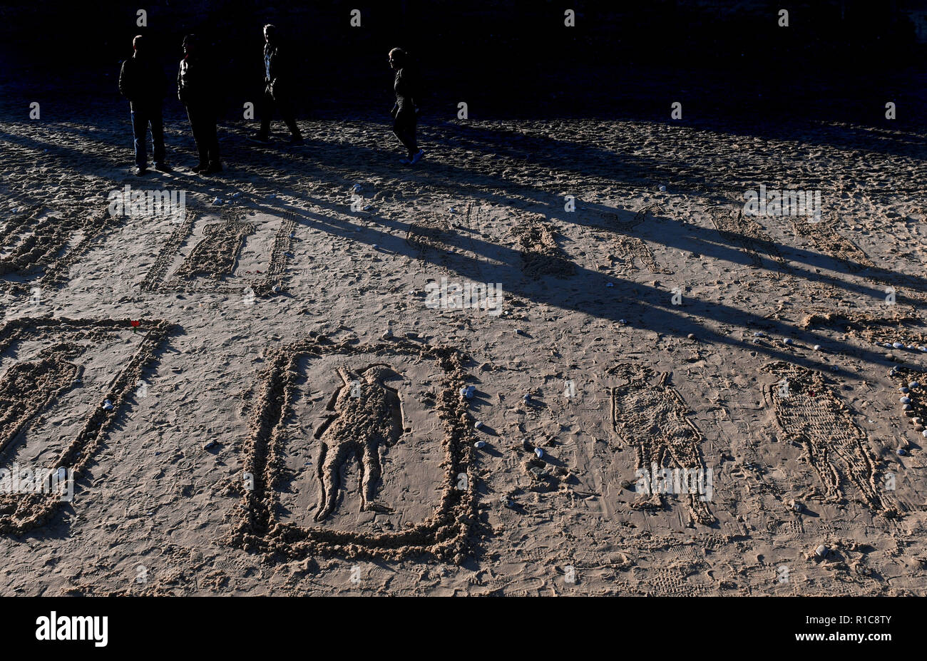 Personnes voir beach dessins sur les pages de la mer activité commémorative à Gorleston-on-Sea à Norfolk, sur le 100e anniversaire de la signature de l'Armistice qui a marqué la fin de la Première Guerre mondiale. Banque D'Images