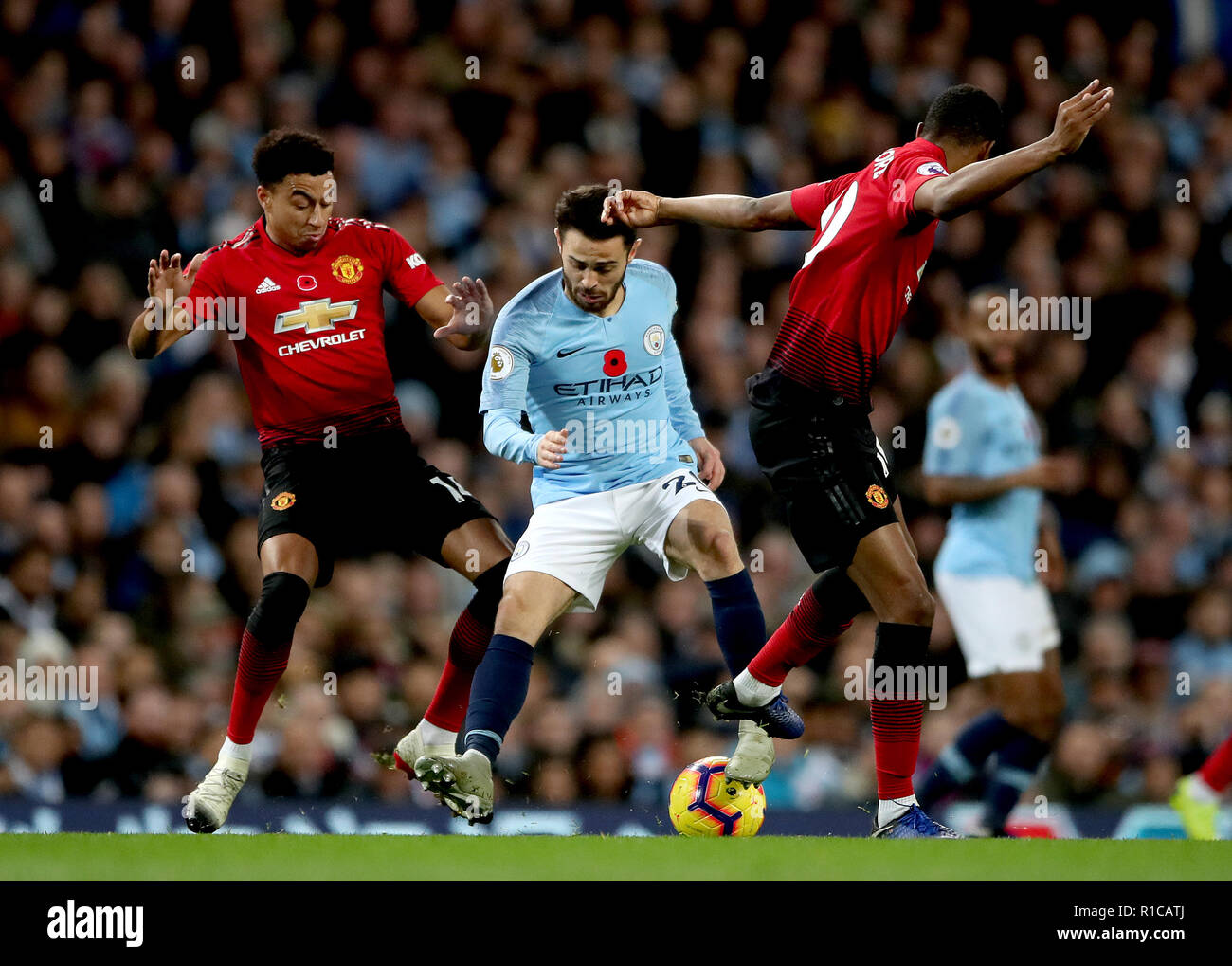 Manchester City's Bernardo Silva (centre) en action que Manchester United's Jesse Lingard (à gauche) et Marcus Rashford Manchester United (à droite) défi pour la balle durant le premier match de championnat à l'Etihad Stadium, Manchester. Banque D'Images