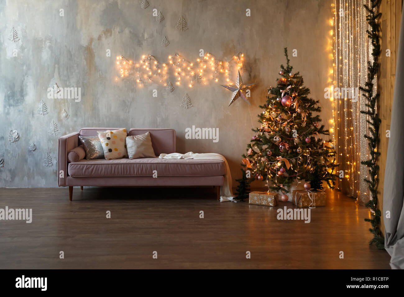 Salon loft sombre décorée pour Noël avec un arbre et des lumières Banque D'Images