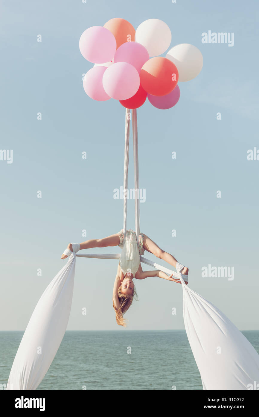 Girl acrobat faire fentes sur les toiles, elle est à l'envers Photo Stock -  Alamy