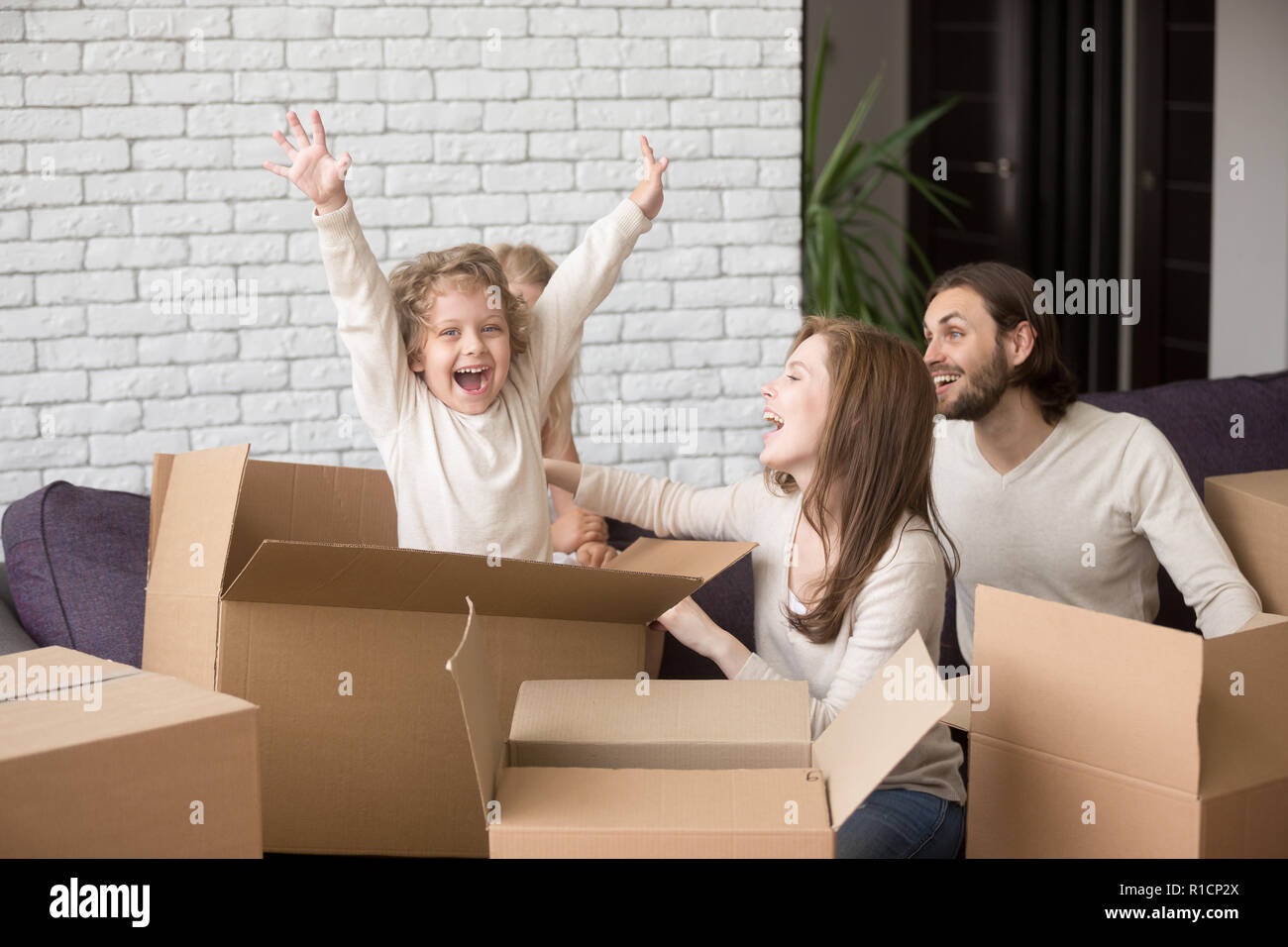 Famille heureuse avec boîtes de carton dans leur nouvelle maison Banque D'Images