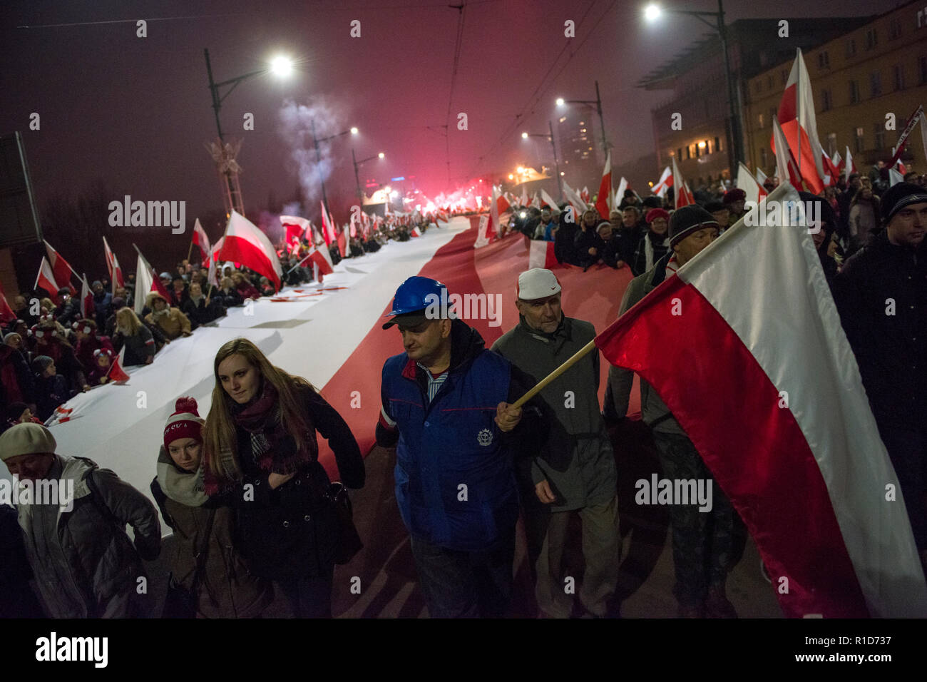 Les gens marcher sur la fête de l'indépendance avec un drapeau national polonais. La Pologne a célébré le 100e anniversaire de sa renaissance en tant qu'Etat indépendant. Environ 200 000 personnes ont pris part à une marche commémorant le jour de l'Indépendance à Varsovie. La marche était constitué de deux rencontres, avec une célébration officielle organisée par le gouvernement suivi d'un autre organisé par la Marche de l'indépendance syndicale. Banque D'Images