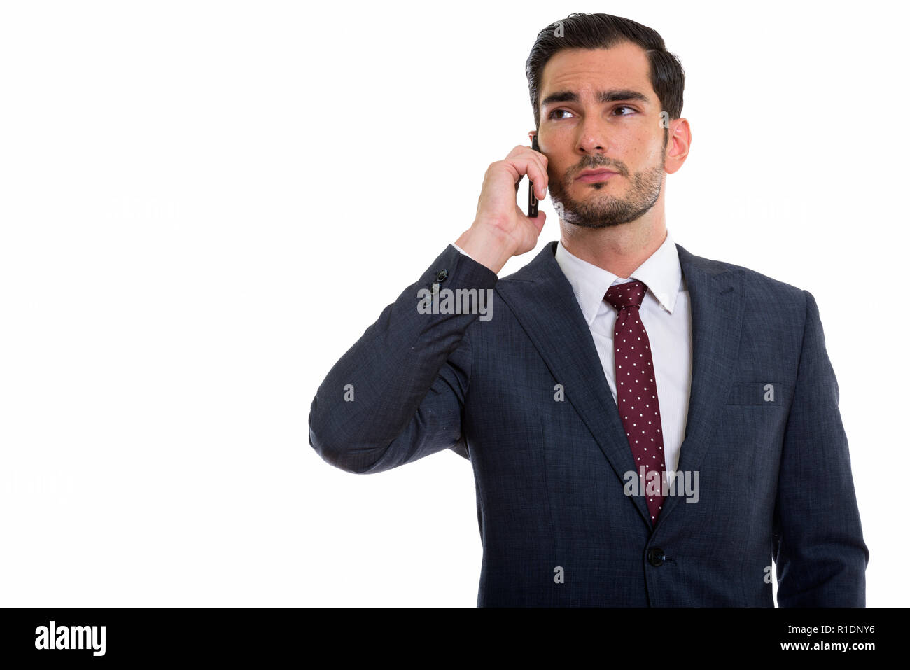 Studio shot of young handsome businessman thinking while looking Banque D'Images