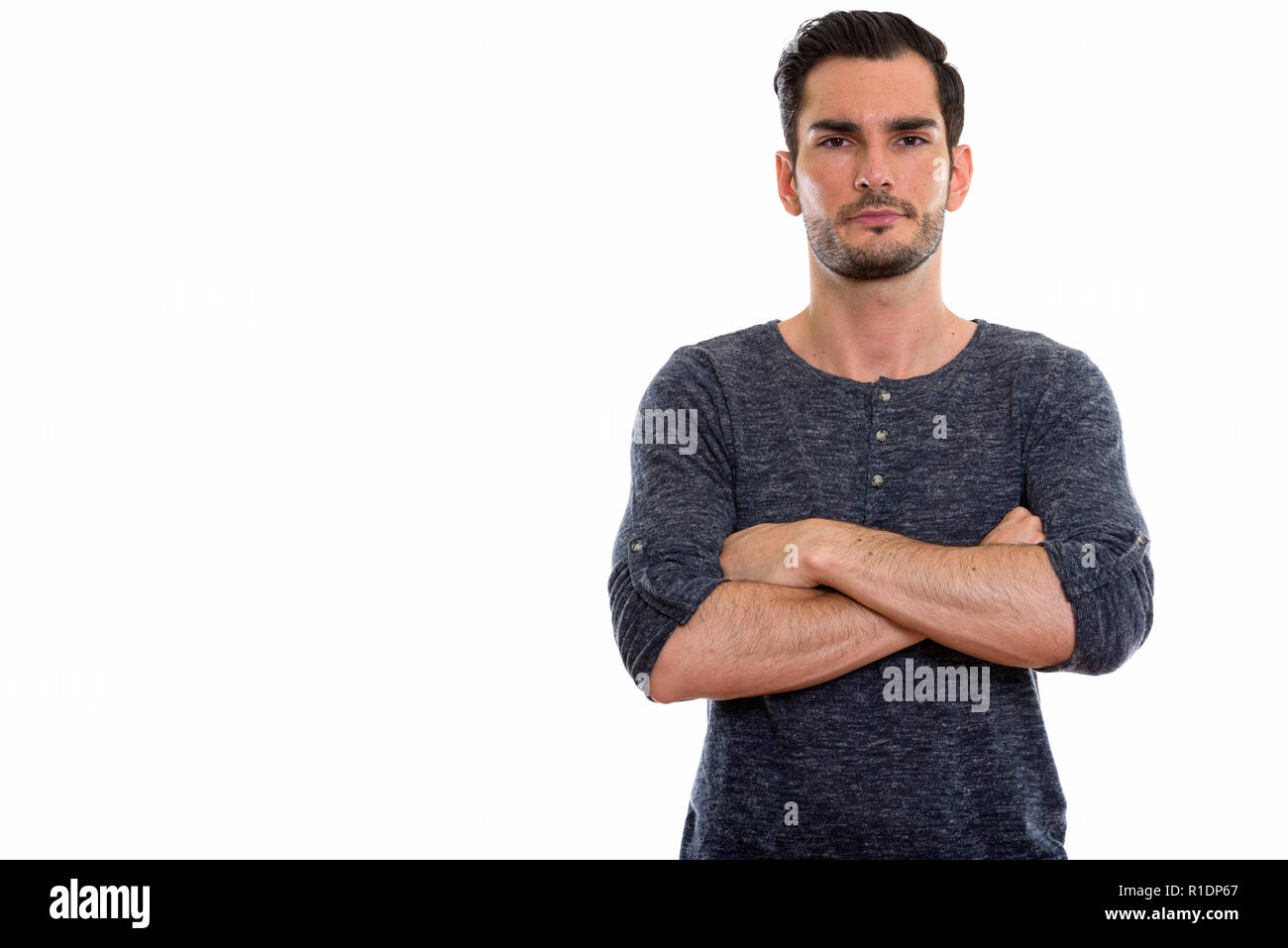 Studio shot of young handsome man with arms crossed Banque D'Images