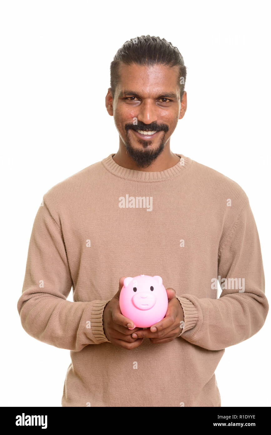 Young happy Indian man holding piggy bank Banque D'Images