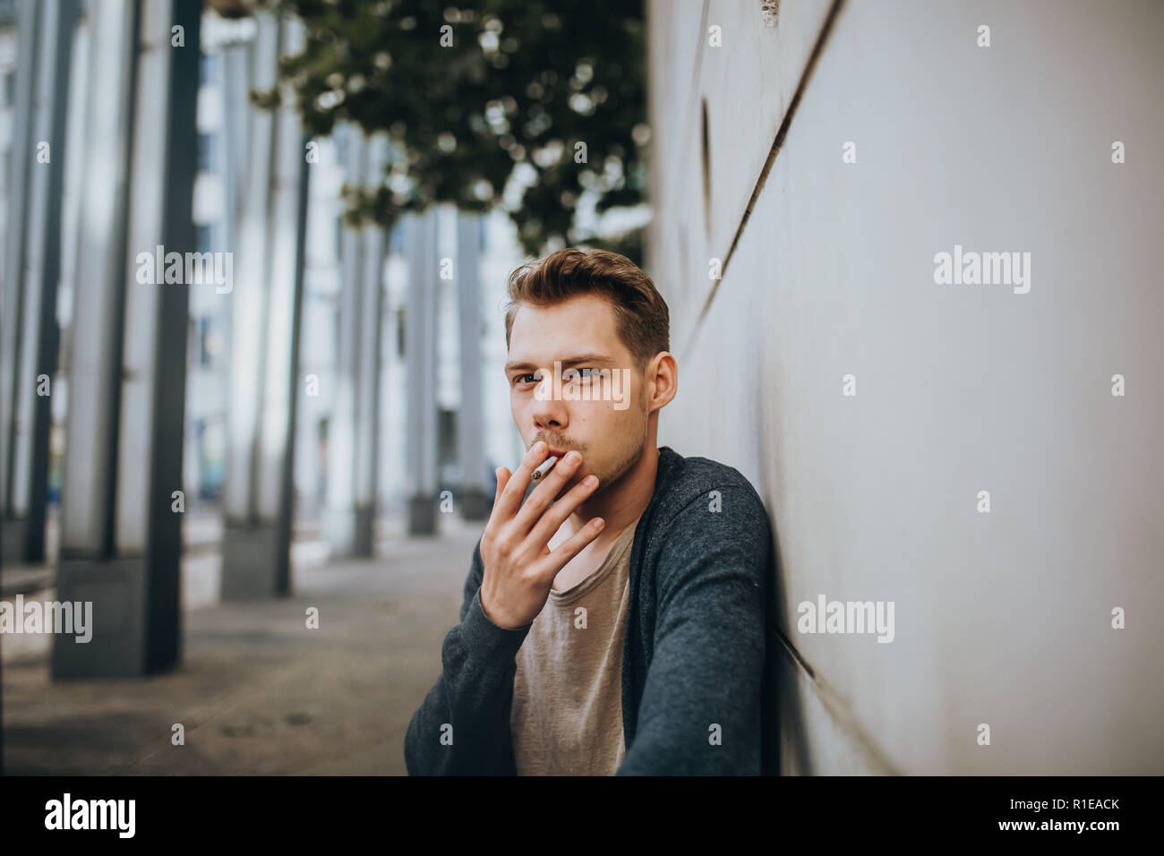 Photo d'un visage d'un jeune homme qui fume une cigarette Banque D'Images