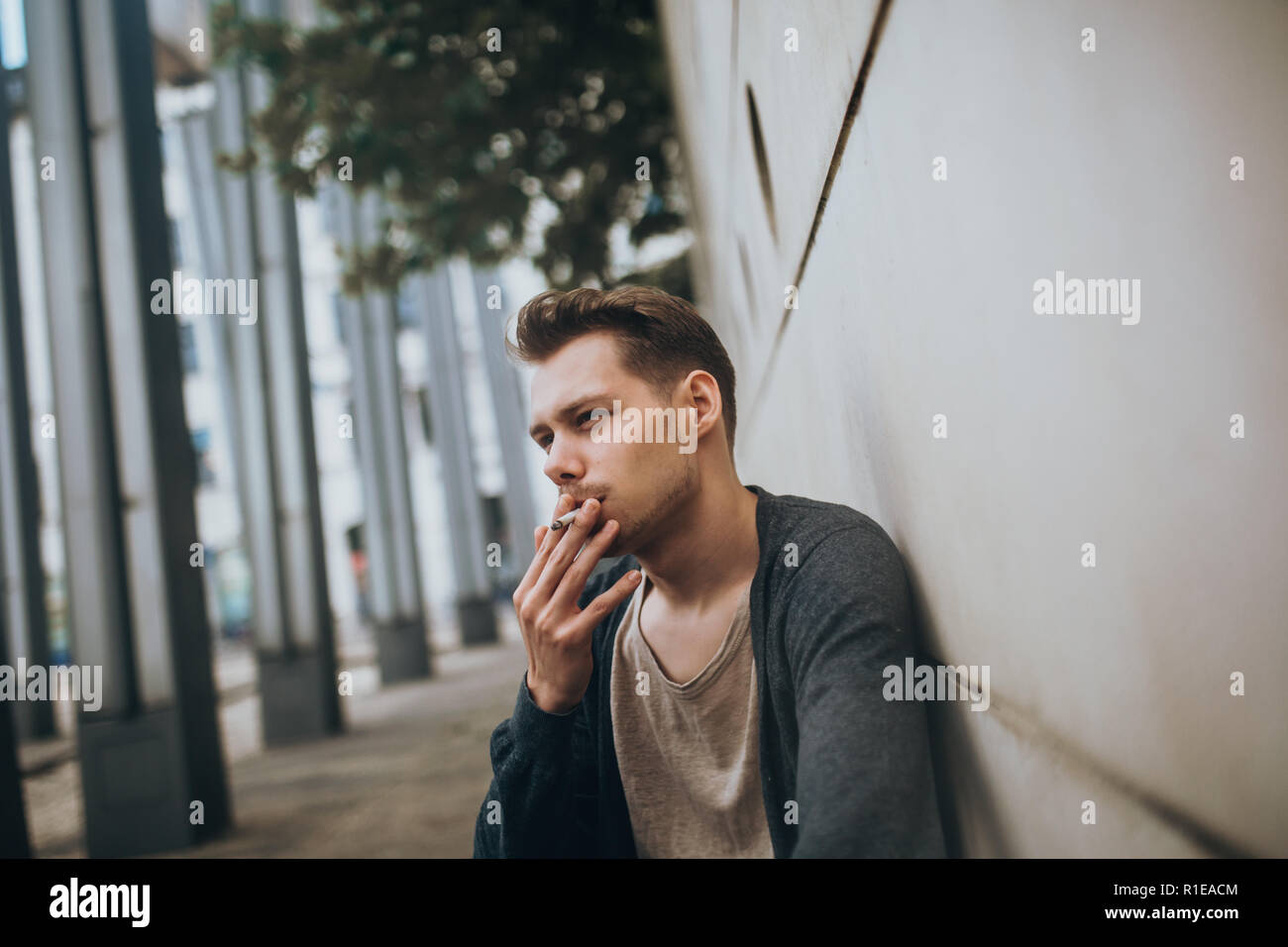 Photo d'un visage d'un jeune homme qui fume une cigarette Banque D'Images