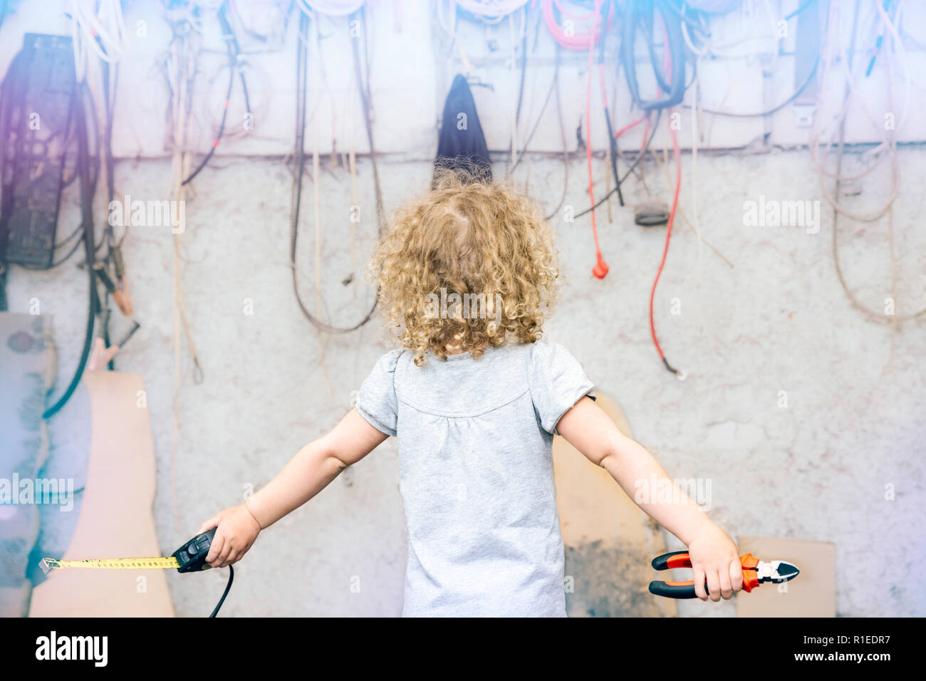 Les jeunes filles main tenant une pince et confrontés à des problèmes de mesure, organise des saletés sur le fond, les problèmes de conquête concept. Banque D'Images