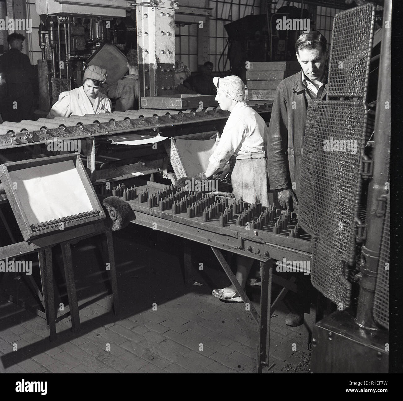 Années 1950, historiques, les femmes portant des bretelles et de filets à cheveux travaillant sur le sol de l'usine à l'usine de batteries toujours prêt, Forest Rd, Londres, Angleterre, Royaume-Uni. Banque D'Images