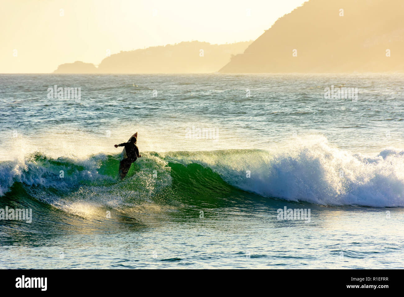 Silhouette de surfeur sur la plage, par la mer à Ipanema, Rio de Janeiro pendant le coucher du soleil Banque D'Images