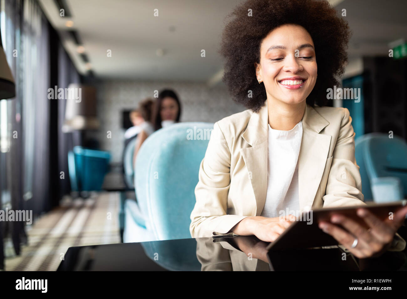 Happy black woman using tablet computer in coffee shop Banque D'Images