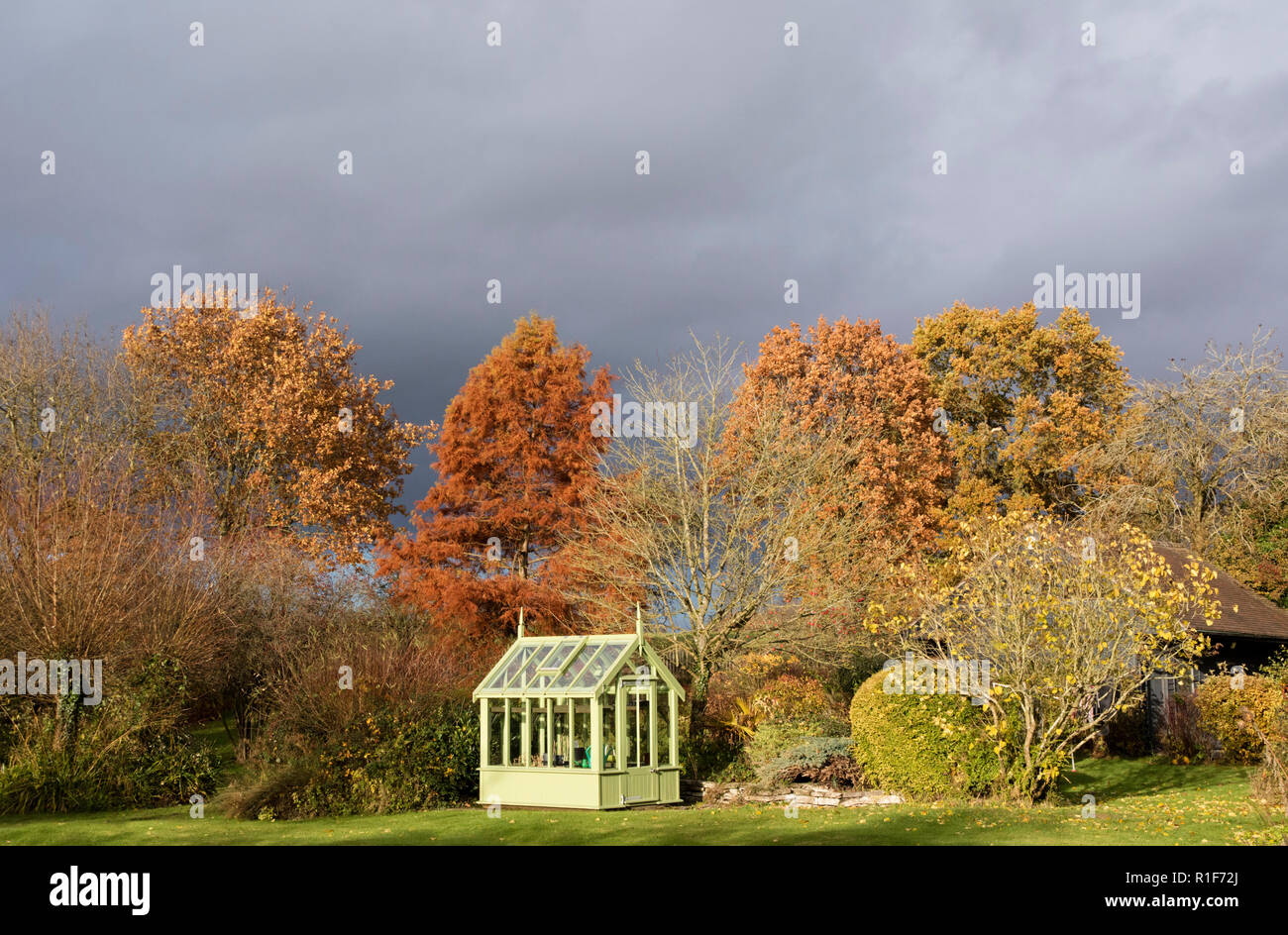 Une maison verte dans un jardin d'automne, England, UK Banque D'Images