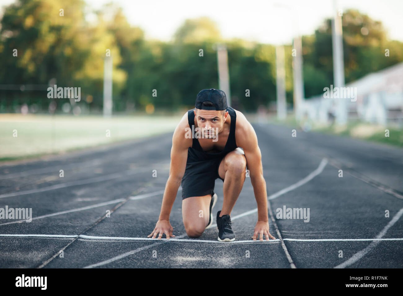 Runner sur le départ. Sprinter sur la ligne de départ de la piste en stadium Banque D'Images