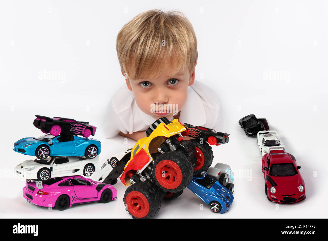 Garçon enfant mignon entouré de jouets voiture Banque D'Images