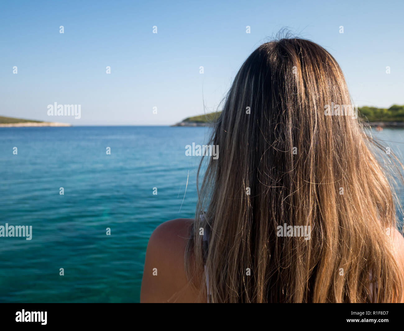 Caucasian woman with long hair comité permanent par la mer bleu sur l'île de Vis en Croatie Banque D'Images