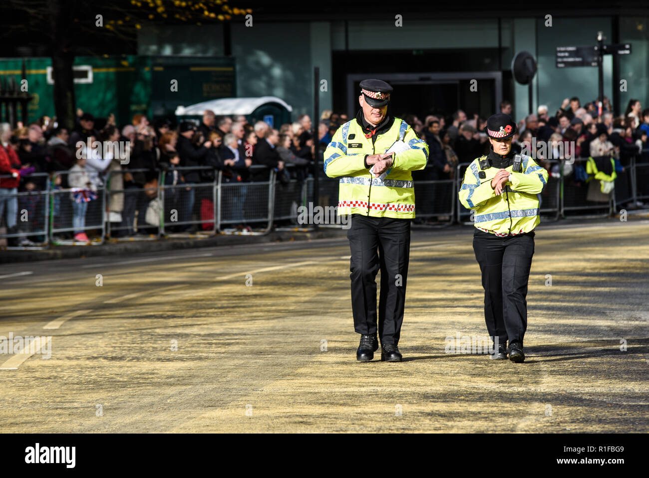 Les agents de police contrôle simultanément leurs montres à l'Éternel Défilé Show du maire de Londres. Vérifier l'heure. La synchronisation des montres. La synchronisation Banque D'Images