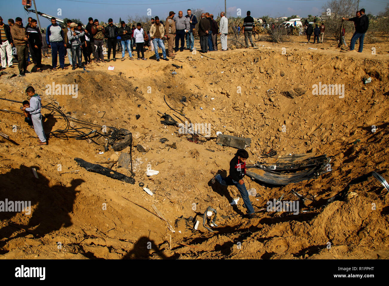 Les Palestiniens de l'Inspection du trou énorme résulte de bombardements israéliens à Khan Younis. De l'air israélienne a effectué la frappe aérienne dans le sud de la bande de Gaza de Khan Younis dans la nuit du 11 Nov causant des dommages à l'immeuble et les droits des victimes. Banque D'Images