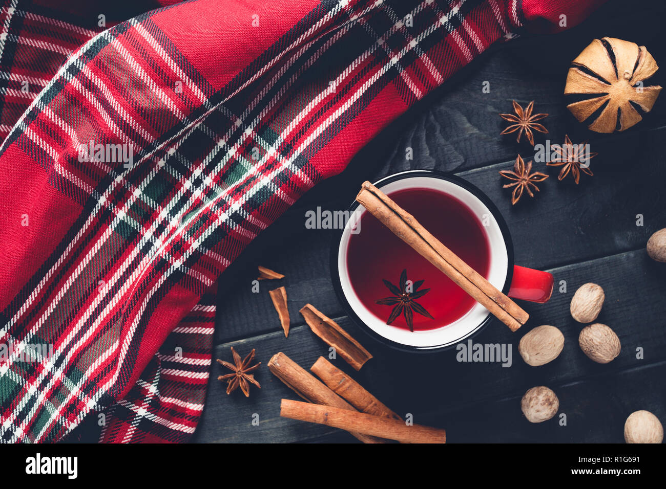 Vin chaud de Noël aux épices dans la tasse rouge sur fond de bois. Banque D'Images