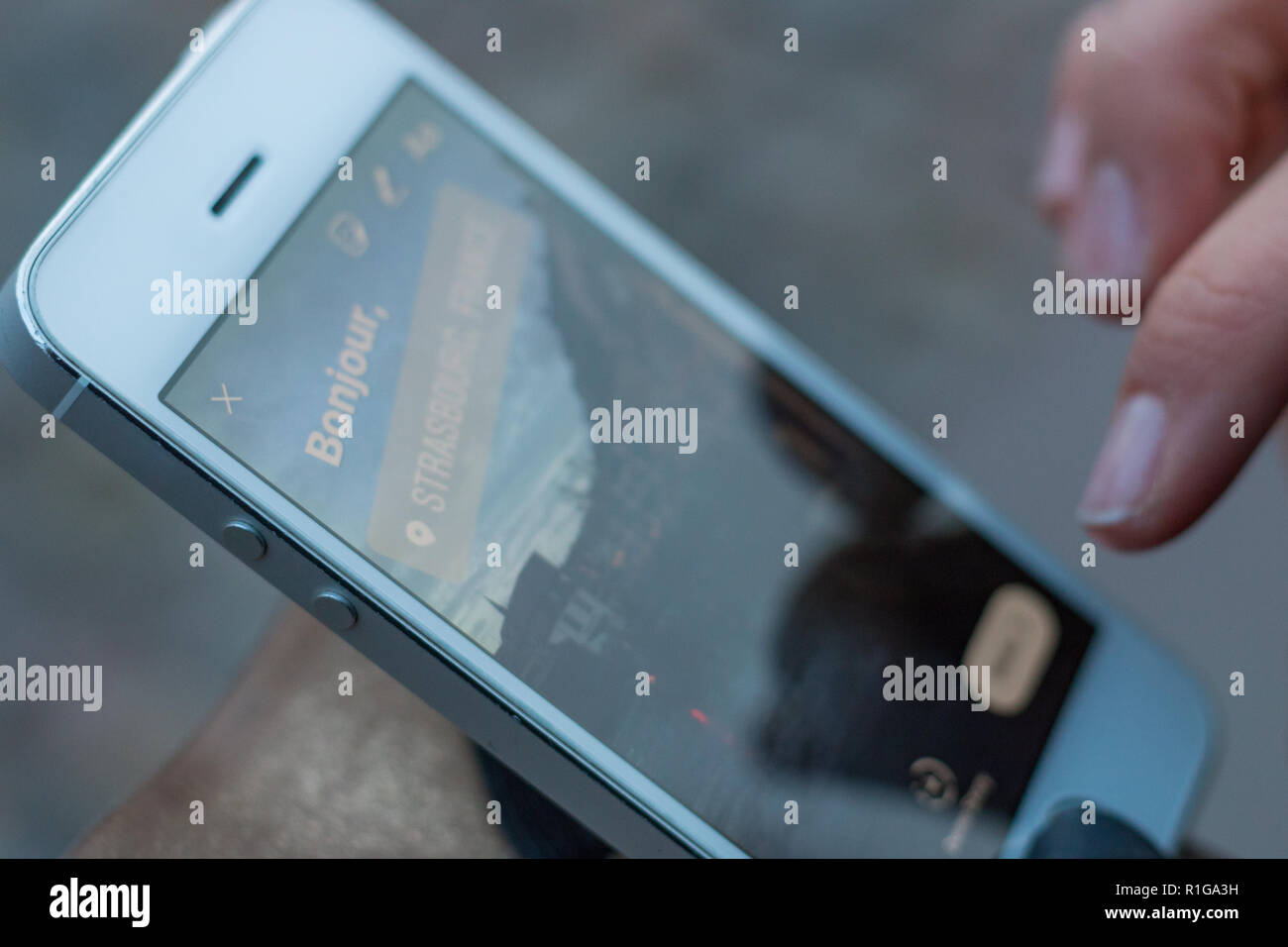 Close-up d'écran du téléphone et un doigt de créer une histoire en disant bonjour Strasbourg Banque D'Images