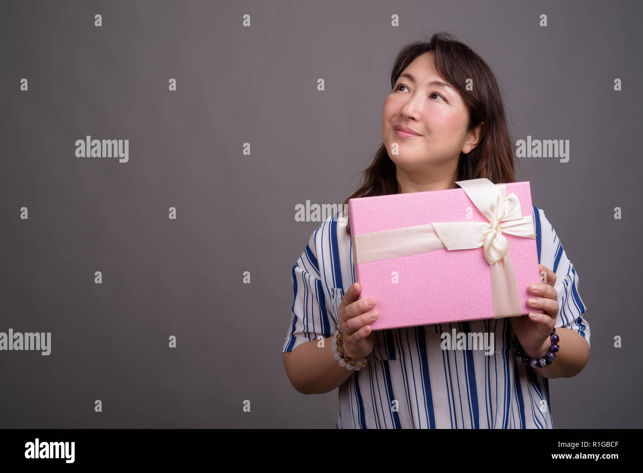 Belle asiatique mature businesswoman holding gift box Banque D'Images