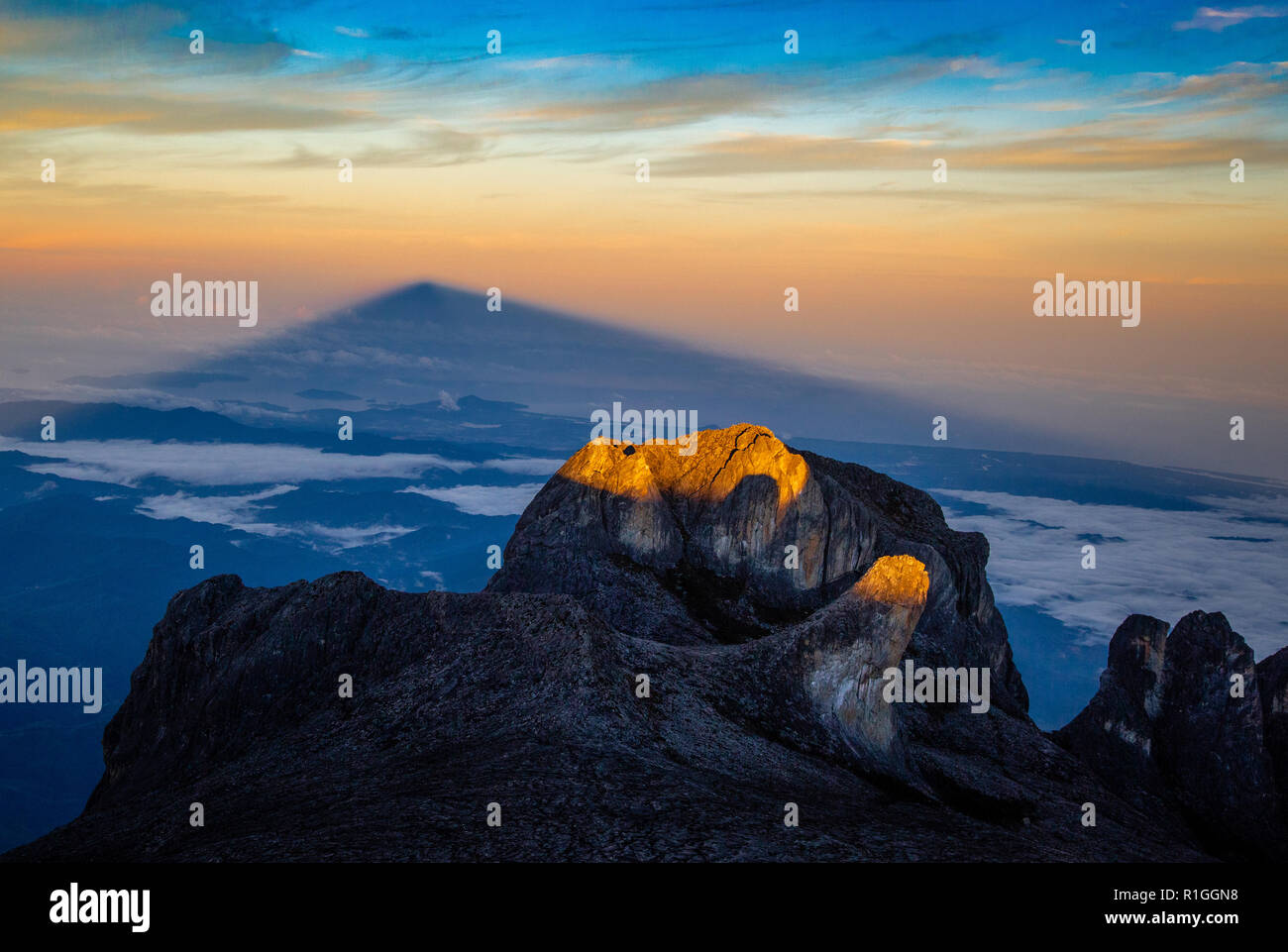 Lever du soleil sur le mont Kinabalu jette une ombre de la montagne sur les brouillards lointain - Sabah Malaisie Bornéo Banque D'Images