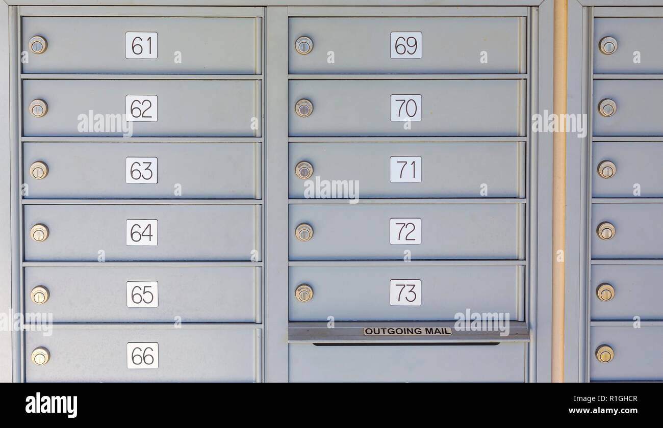 Des rangées de boîtes aux lettres privées numérotées en kiosque dans un quartier Banque D'Images