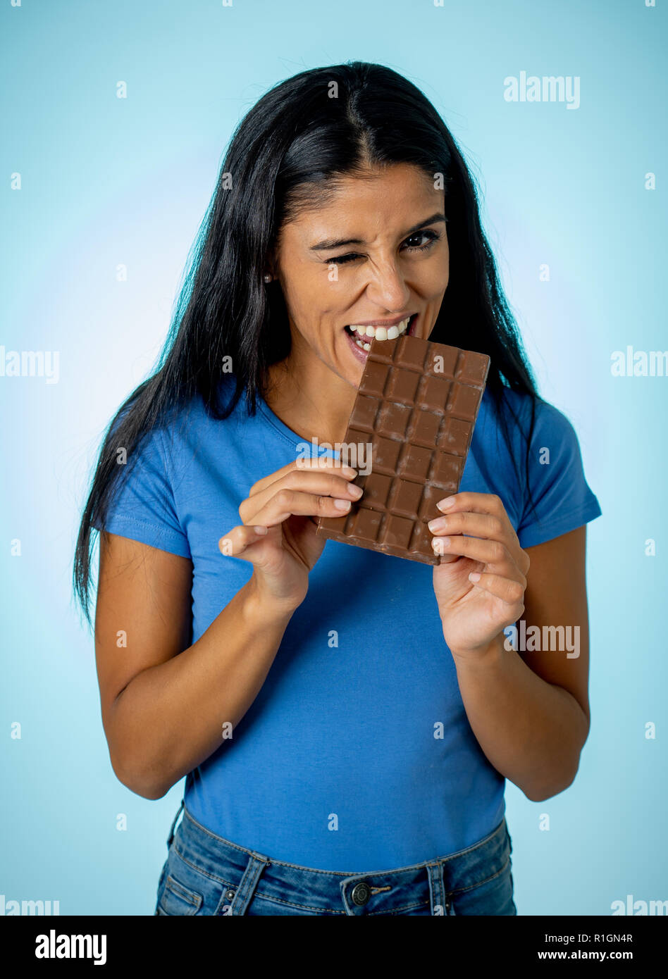 Belle jeune femme latine mignon et heureux dans les tenues de holding big  tablette de chocolat délicieux à la tentation de penser si ignorant  l'alimentation Photo Stock - Alamy